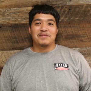 Headshot of co-foreman, James Vasquez, taken at the San Antonio office. He is wearing a gray Baird t-shirt.