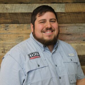 Headshot of foreman, Mark Perez, taken at the San Antonio office. He is smiling and wearing a light blue Baird fishing guide shirt.