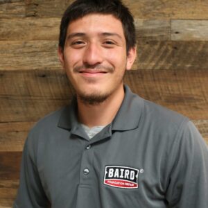 Headshot of foreman, Daniel Montoya, taken at the San Antonio office. He is smiling and wearing a dark gray Baird polo shirt.