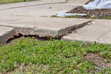 Sunken concrete driveway showing severe cracking