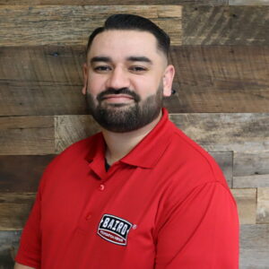 Headshot of the system design specialist, Kenny Watson, taken at the San Antonio office. He is wearing a red Baird Foundation Repair polo shirt.
