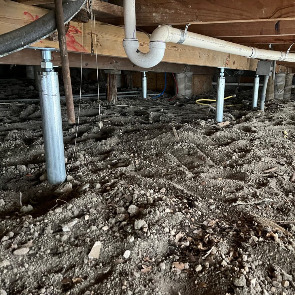View of a crawlspace in a pier and beam home with steel SmartJacks installed.