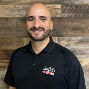 Headshot of Baird Foundation Repair's Controller, Chris Espinosa. He is wearing a black Baird polo shirt.