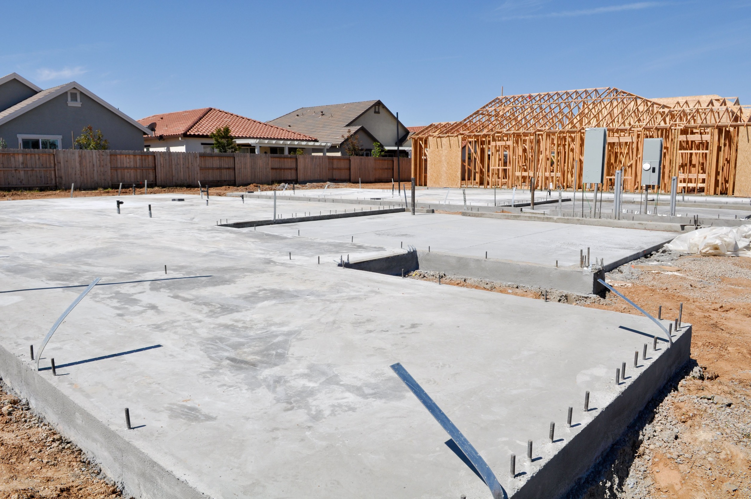 concrete slab foundation recently laid in a neighborhood of new build home