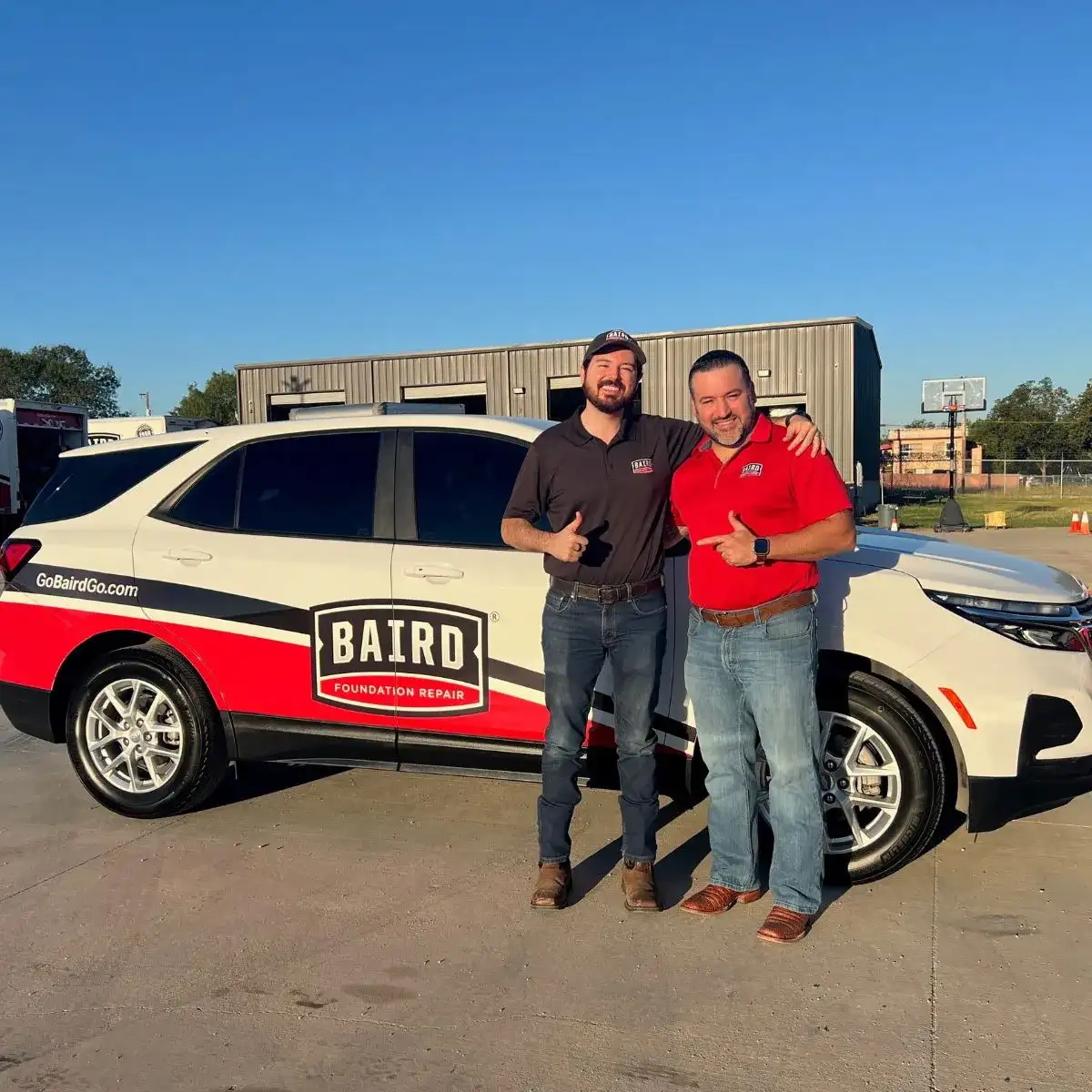 SDS and Director of Sales smile in front of a baird vehicle.