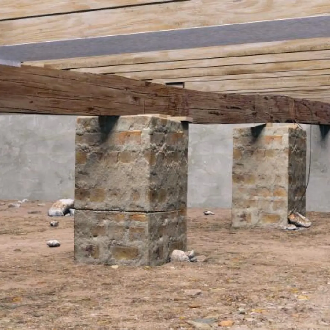 Aging stone pier supports beneath a crawl space foundation prior to structural leveling and reinforcement in San Antonio.