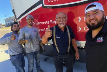 Baird Foundation Repair crew members giving thumbs up in front of a company service truck after completing a foundation repair job in Corpus Christi, TX.