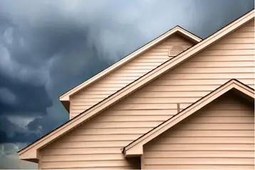 Storm clouds gathering over residential rooftop
