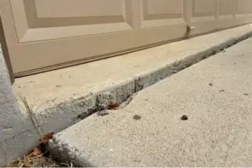 Home in San Antonio with a trip hazard in their driveway before concrete repair.