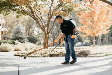 Production team member putting SealantPro on a customers driveway